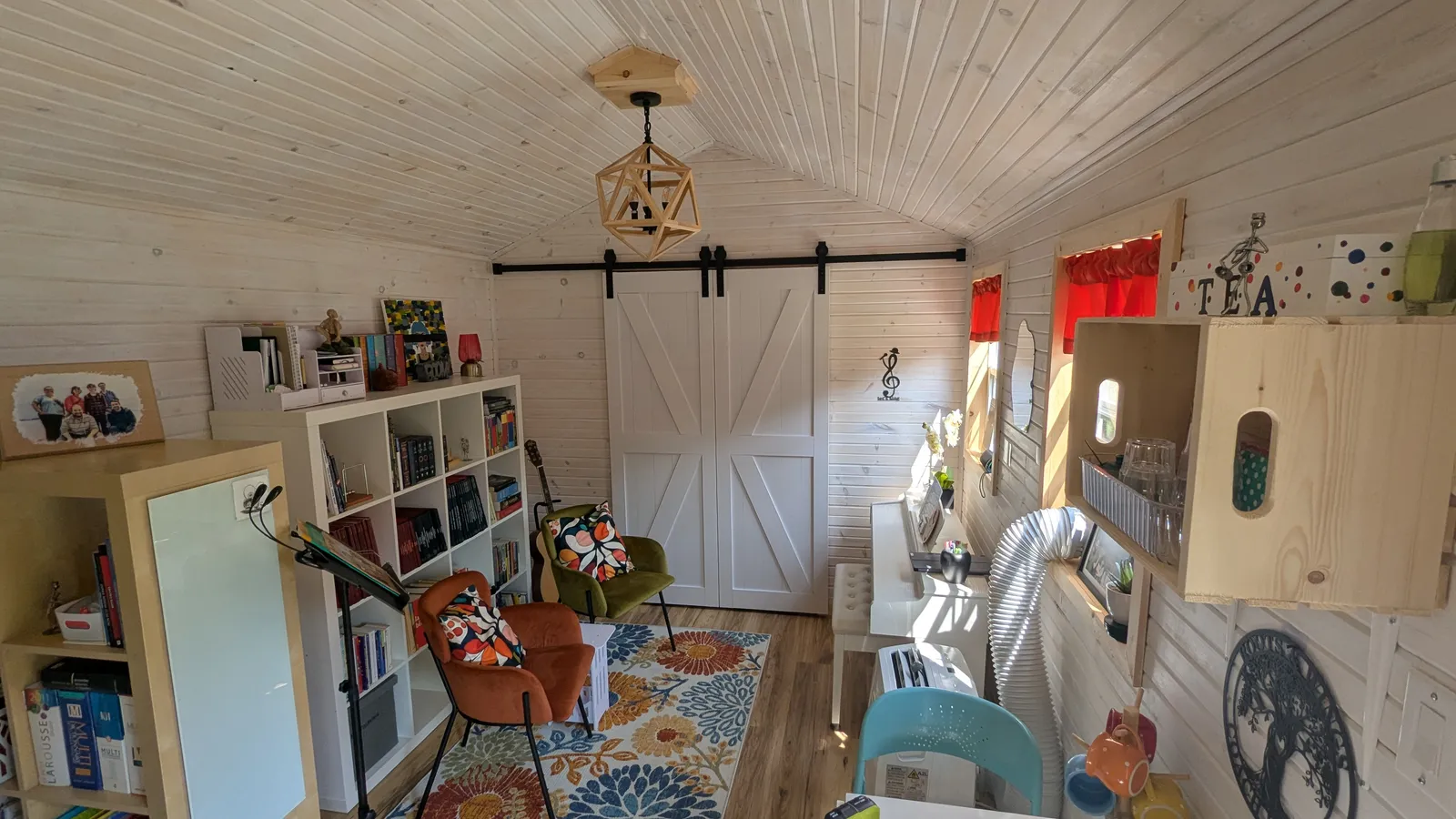 L’intérieur du studio de Prélude Musique : murs de bois clair, bibliothèque, fauteuils et coin musique baigné de lumière.